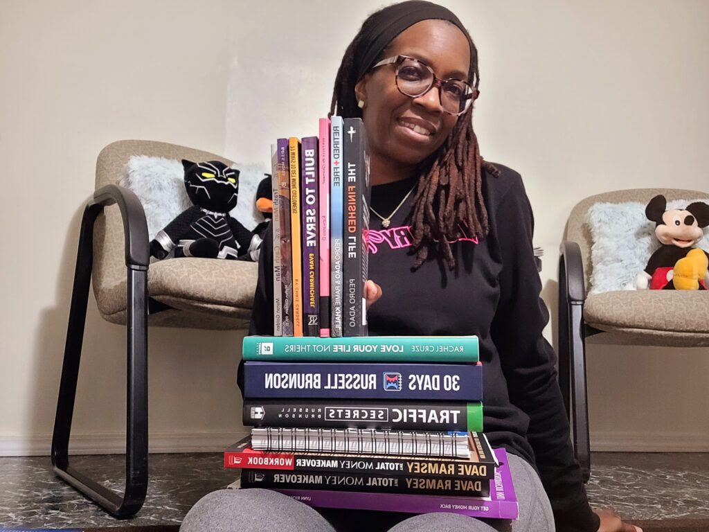 A woman sitting in front of a stack of books.