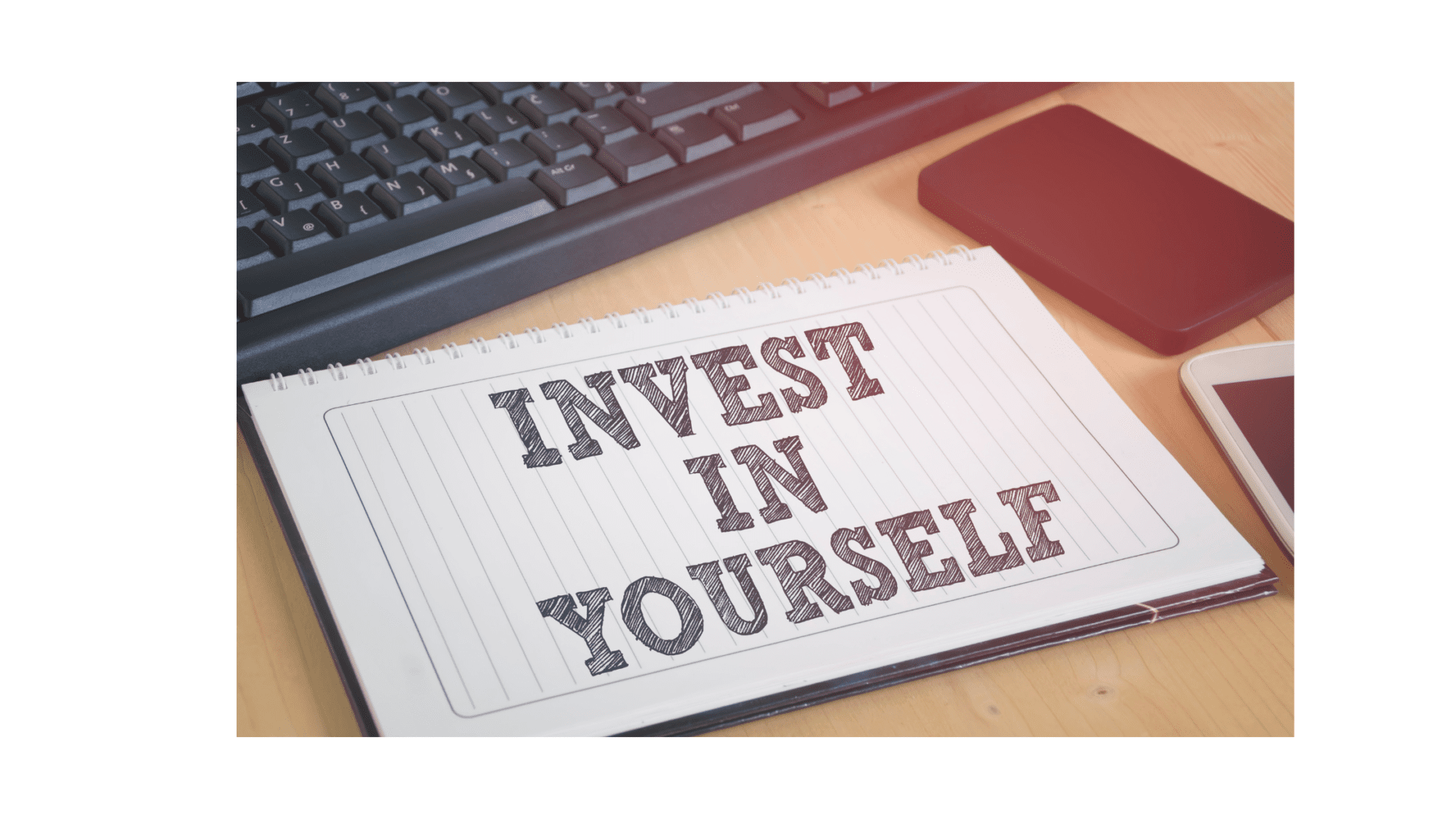 A notebook with the words invest in yourself written on it.